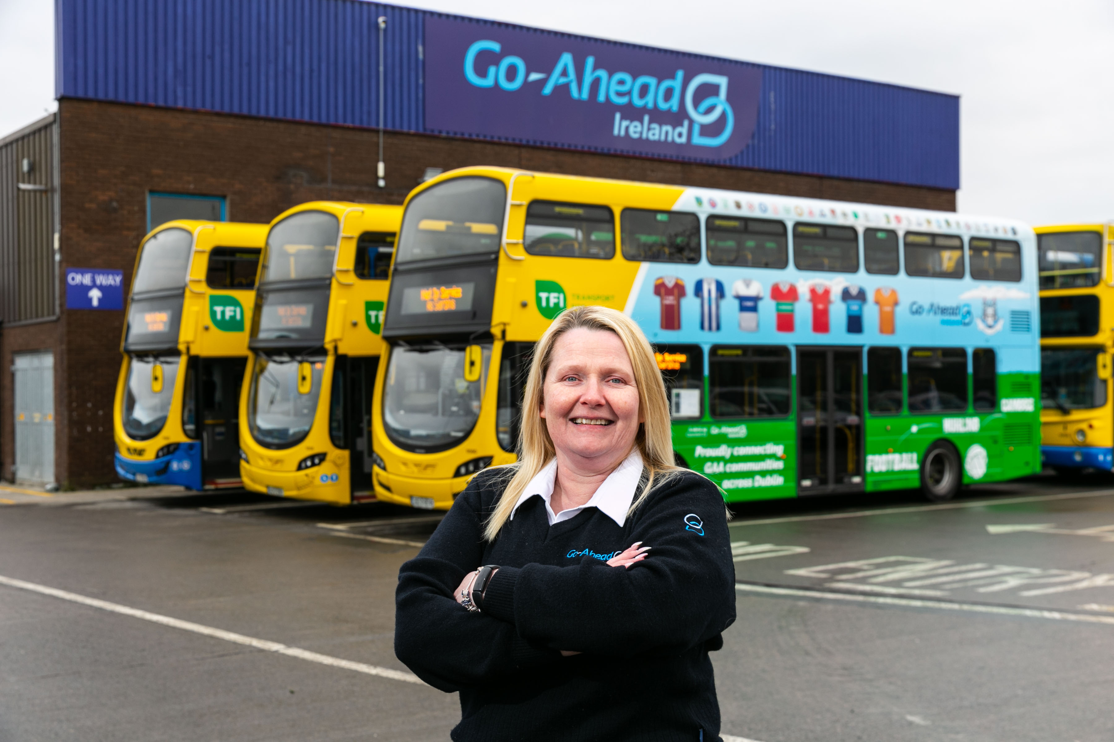 Driver standing in front of the Go-Ahead Ireland depot and some of its fleet of buses. 